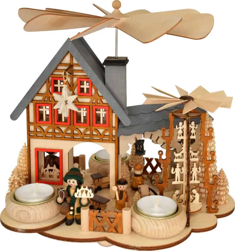 Wooden Christmas pyramid house with rotating figurines and candles for festive decor.