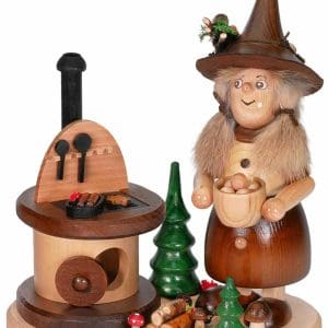 Wooden witch figurine with a cauldron and miniature trees for holiday decor.